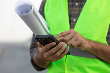 engineer working on his smartphone at the construction site