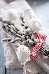 Handmade easter eggs with willow catkins on a linen napkin