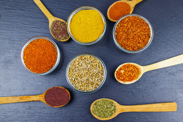 Set of different aromatic spices on black slate. Top view