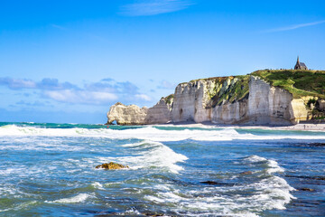 Obraz premium Etretat Aval cliff, rocks and natural arch landmark and blue ocean. Normandy, France, Europe. Beatiful summer panorama.