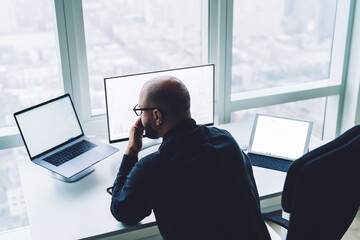 Anonymous pensive analyst watching laptop screen at office table
