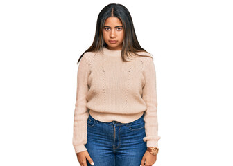 Young latin girl wearing wool winter sweater skeptic and nervous, frowning upset because of...