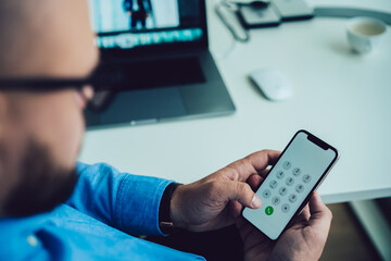 Crop unrecognizable man using smartphone in office