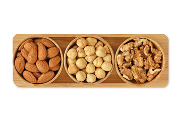 Almons, hazelnuts and walnuts in wooden bowls on white background