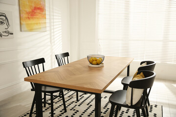 Stylish wooden dining table and chairs in room. Interior design