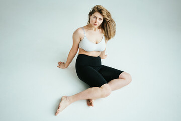 Natural blond hair plus size model woman wearing underwear in white photo studio