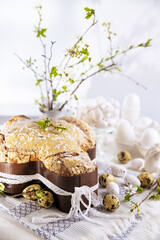 Obraz na płótnie Canvas Traditional Italian desserts for Easter - Easter dove . Festive pastries with almonds and sugar icing on a light background and flowering branches, Easter decor and eggs. close-up. Vertical