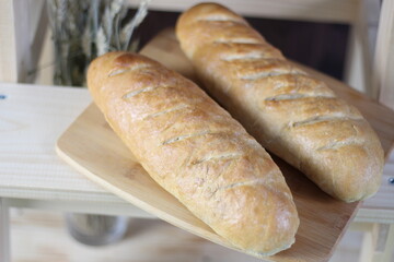 two loafs of wheat bread on wooden board