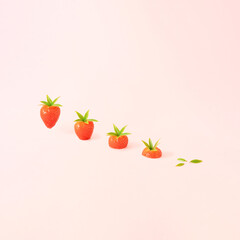 Minimal spring composition made of sliced strawberries on pastel pink background. Surreal nature background.