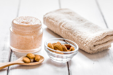 body scrub with almonds for body care on light table background