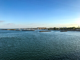 Obraz premium Marina and park with palm trees, grass, water in Fort Pierce, Florida with sidewalk, boardwalks and bridges to walk and ride along the path