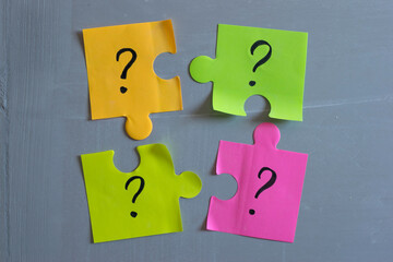 Obraz premium Question marks on paper puzzle notes on the cement wall.