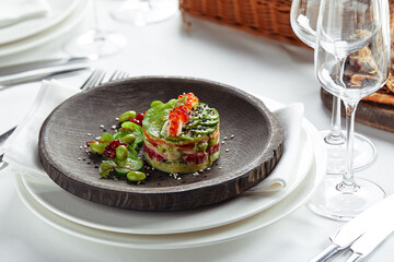 Salad of avokado, seafood, meat, vegetables and pumpkin seeds. Dietary, wholesome and tasty. Banquet festive dishes. Gourmet restaurant menu. White background.