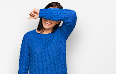 Young hispanic woman wearing casual clothes covering eyes with arm smiling cheerful and funny. blind concept.