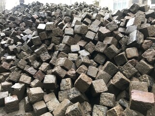 bunch of paving stones on a city street blocked off with a construction tape, road repairs reconstruction of the historical part of the city, selective focus