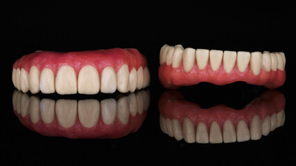 maxillary and mandibular wax up with pink gums on a black background with reflection