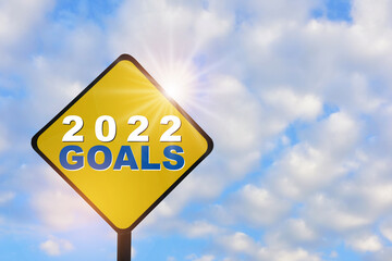 New year 2022 goals on yellow sign on beautiful blue sky with fluffy cloud background. Leadership concept and think different idea