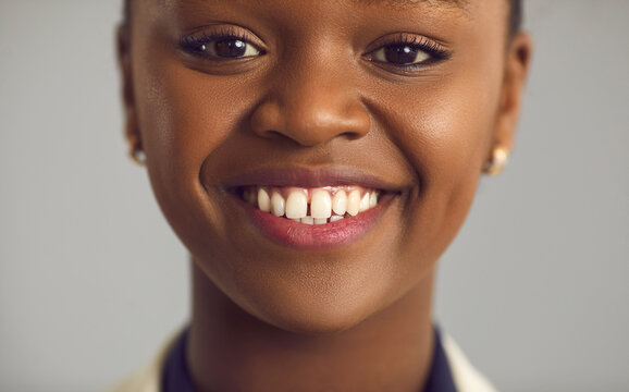 Headshot Portrait Of Happy Glad Pretty Young Black Woman With Nude Makeup, Gap Between Upper Front Teeth And Charming Toothy Smile. Human Face, Women's Beauty, People's Appearance, Dental Care Concept