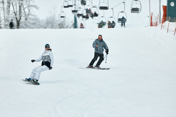 Downhill skier. Snowboarders and skier ride on snow in the mountains. Downhill ride. Adventure...