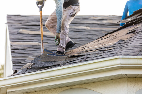 roofer removing roof nails with roof shingle remover