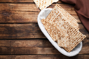 Traditional matzos in basket on wooden table, flat lay. Space for text