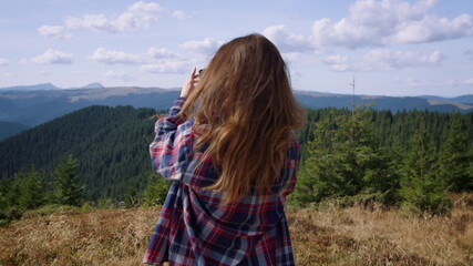 Young woman making panoramic photo of natural landscape on mobile phone