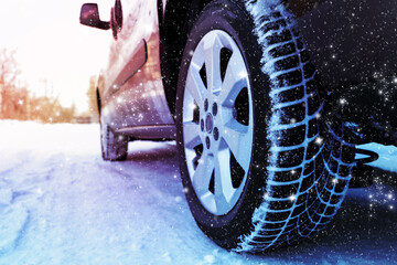 Car with winter tires on snowy road, closeup view