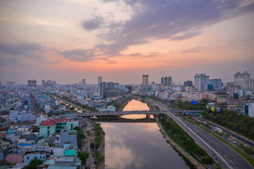 Fototapeta na wymiar Sunset, bridge, canal, reflection and urban sprawl of Ho Chi Minh City District Eight 