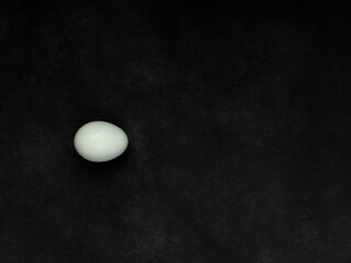 Fresh white chicken eggs, top view, on a black textured background. Creativity.