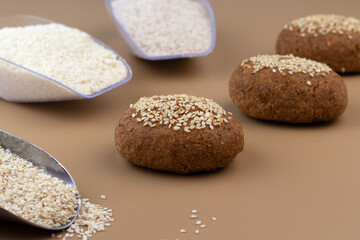 Fototapeta na wymiar A healthy gluten-free keto bread made from almond flour and psyllium husk, sprinkled with sesame seeds. Baking ingredients in scoops. Ketogenic diet, paleo, low carb, high fat.