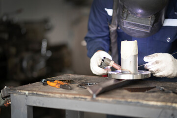 Strong man welder in work clothes hard working and welds with a welding machine metal ,Close-up of a welder wielding sparks