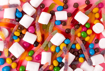 Background. The texture of a lot of sweets on a pink background. View from above. Copy space