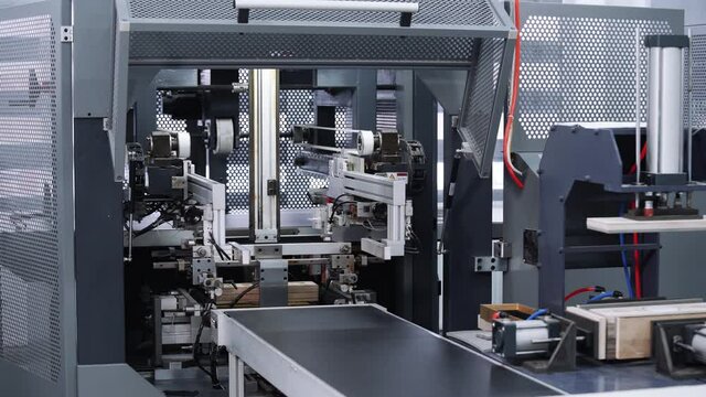Modern automatic machine line of cardboard box. Conveyor line for the production Manufacture of cardboard boxes from paper. gluing of cardboard.