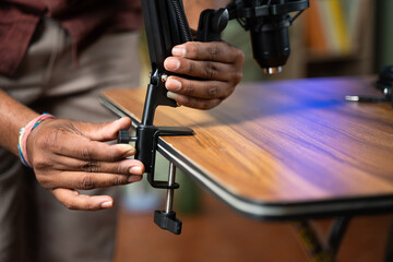 Close up of vloggers hands setting up hands podcast mike equipment or microphone set to table in studio