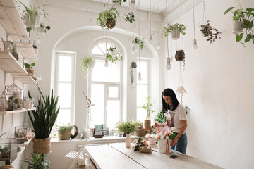 florist work brunette girl and a bouquet of flowers on the table in a stylish room