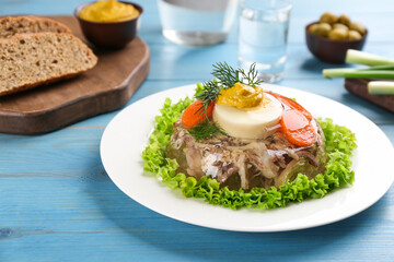 Delicious aspic with meat and vegetables served on light blue wooden table