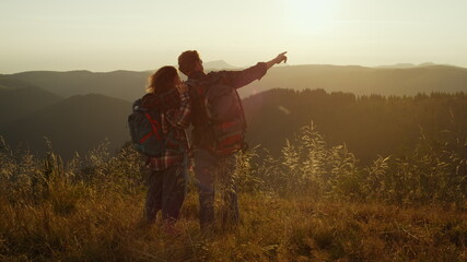 Man and woman having adventure in mountains. Hikers embracing together