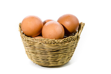 Fresh eggs inside a wicker basket on white background. Copy space