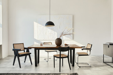 Minimalist composition of dining room interior with wooden table, design chairs, dried flowers in a...