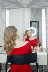 the beautiful blonde admires her hair in a beauty salon