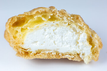 Cupcake with cream on the white plate. Sweet dessert for breakfast. Close up view of cut in half cake inside.