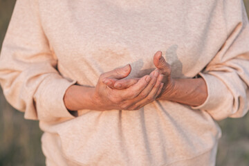 Close-up of an elderly woman's hands in nature