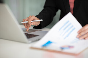 Close up of Accounting businesswoman working on note laptop computer and analyzing real estate investment data, Financial and tax systems concept.