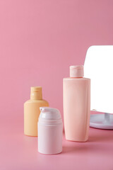 Tubes of cosmetic cream, facial product, skincare blank bottle packaging on pink background. Beauty and spa concept.