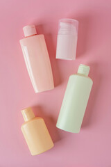Set of cosmetic skin care products, facial product, skincare blank bottle packaging on pink background. Beauty and spa concept.