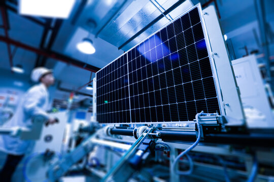 Factory workers lifting new solar panel from production line,and  the technician is checking it in the factory.Intelligent industrial background image.