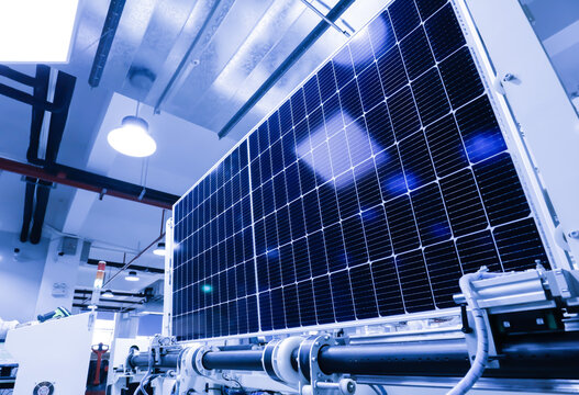 Factory workers lifting new solar panel from production line,and  the technician is checking it in the factory.Intelligent industrial background image.