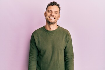 Young hispanic man wearing casual clothes with a happy and cool smile on face. lucky person.