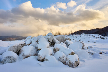 Marble boulders covered with snow on an old site, on the top of a mountain.