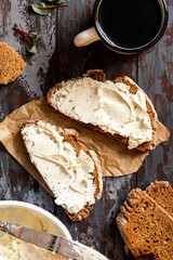 Rustic breakfast. Sandwich with soft cheese and rye bread on a dark wooden background top view. Ricotta sandwich and coffee.